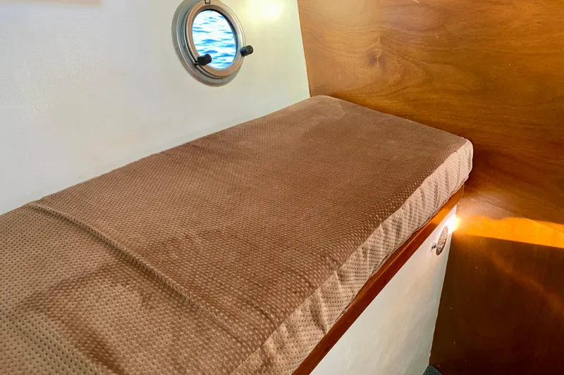 Slide: The Image of Interior of 1979 Outer Reef 26/31 boat with cushioned bench and porthole. - 85