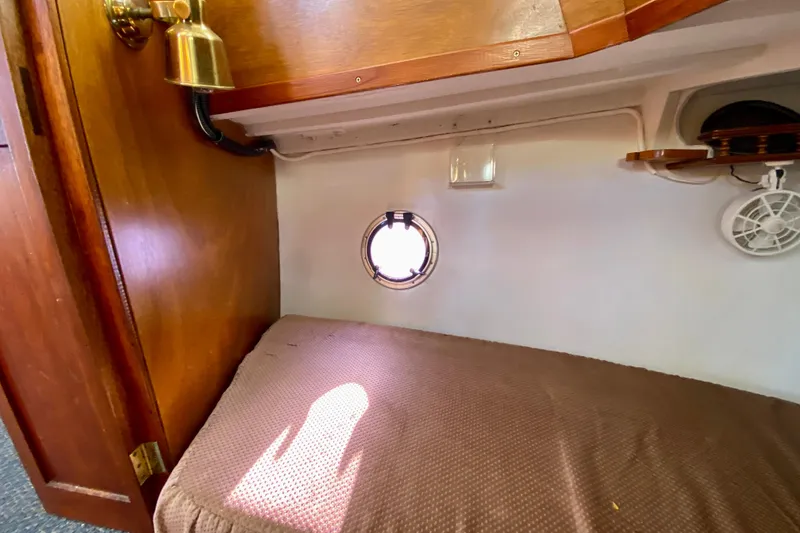 Slide: The Image of Cozy cabin interior of 1979 Outer Reef 26/31 boat with porthole and wooden accents. - 89