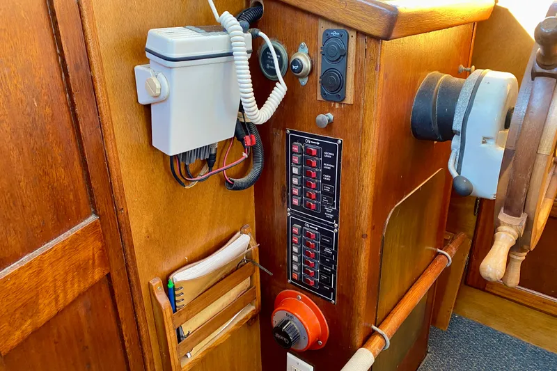 Slide: The Image of 1979 Outer Reef 26/31 boat helm with control panel and wooden steering wheel. - 95