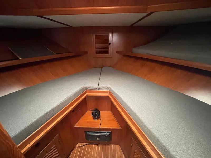 Slide: The Image of 1986 Kha Shing Spindrift yacht docked, featuring a white and blue exterior under a cloudy sky. - 13