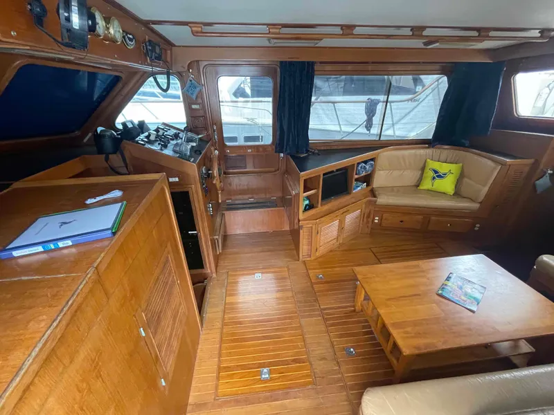 Slide: The Image of Interior of a 1986 Kha Shing Spindrift yacht with leather sofas and wooden table. - 17