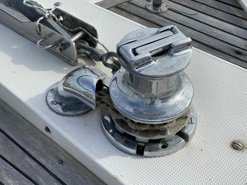 Slide: The Image of Bow view of 1986 Kha Shing Spindrift yacht navigating a serene river under a bridge. - 51