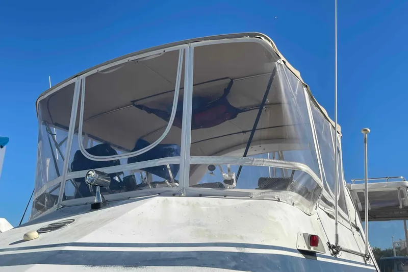 Slide: The Image of 1986 Kha Shing Spindrift boat with clear enclosure under a bright blue sky. - 55