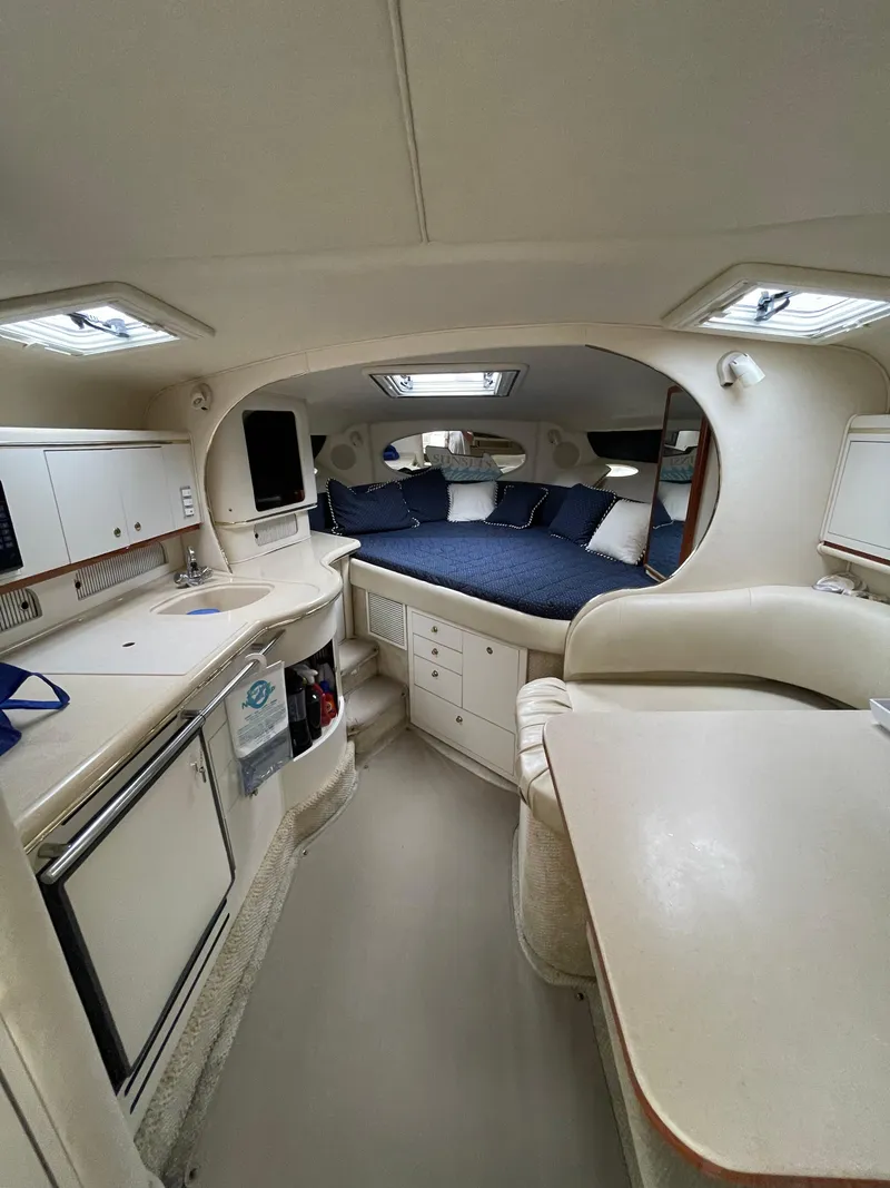 Slide: The Image of 2001 Sea Ray 310 Sundancer cabin interior with kitchenette, seating, and sleeping area. - 15