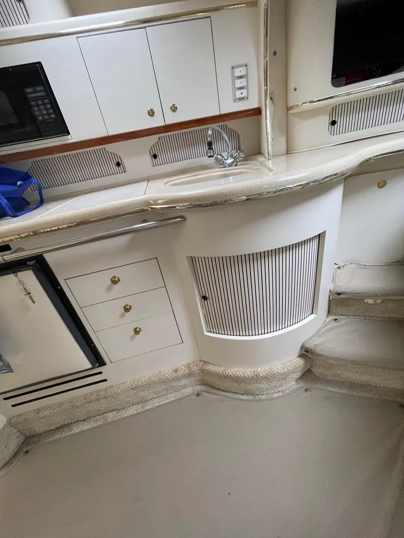 Slide: The Image of 2001 Sea Ray 310 Sundancer interior with kitchenette and storage cabinets. - 21
