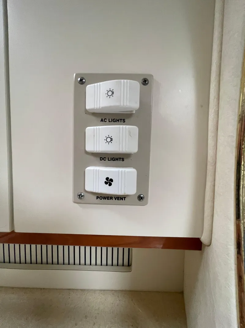 Slide: The Image of Control panel on a 2001 Sea Ray 310 Sundancer for AC/DC lights and power vent. - 23