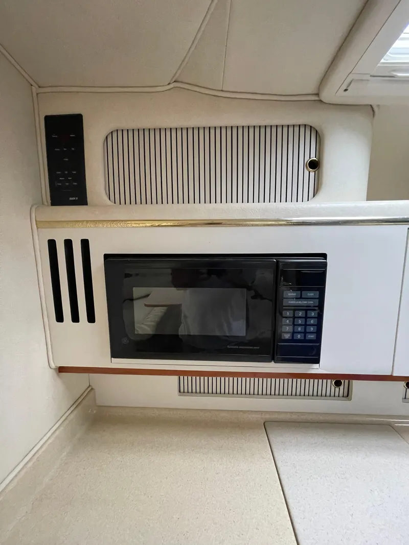 Slide: The Image of 2001 Sea Ray 310 Sundancer interior with built-in microwave and cabinetry. - 24