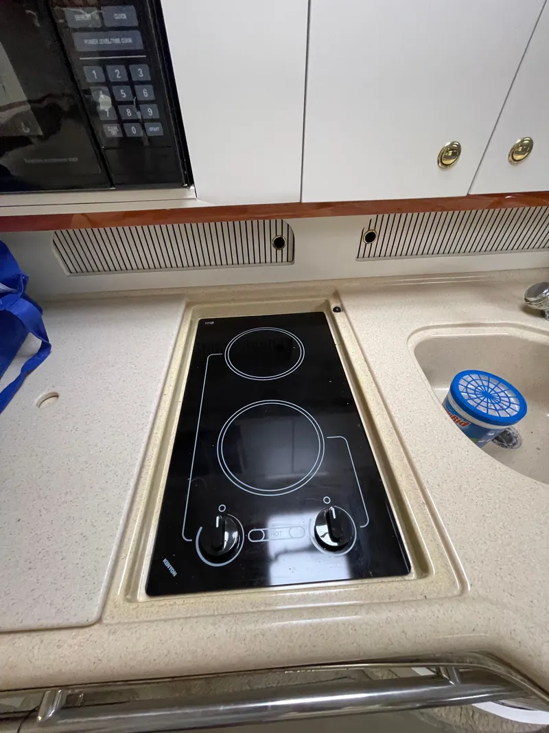 Slide: The Image of 2001 Sea Ray 310 Sundancer kitchen with stovetop and sink. - 26