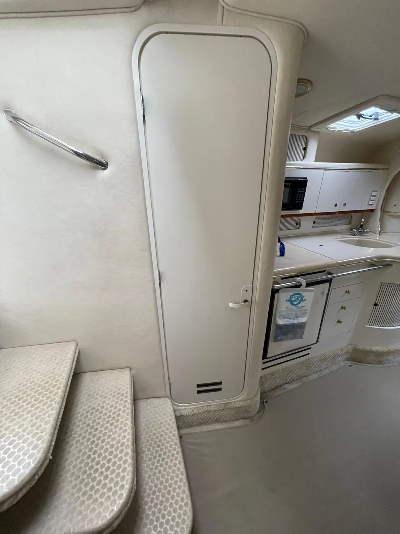 Slide: The Image of Interior of 2001 Sea Ray 310 Sundancer yacht, featuring stairs and kitchenette. - 33