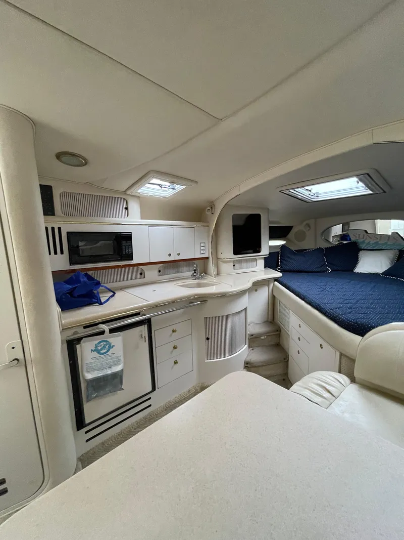 Slide: The Image of Interior of 2001 Sea Ray 310 Sundancer yacht with kitchenette and cozy sleeping area. - 35