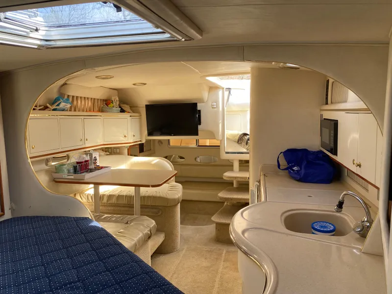Slide: The Image of Interior of 2001 Sea Ray 310 Sundancer yacht with kitchenette and seating area. - 46