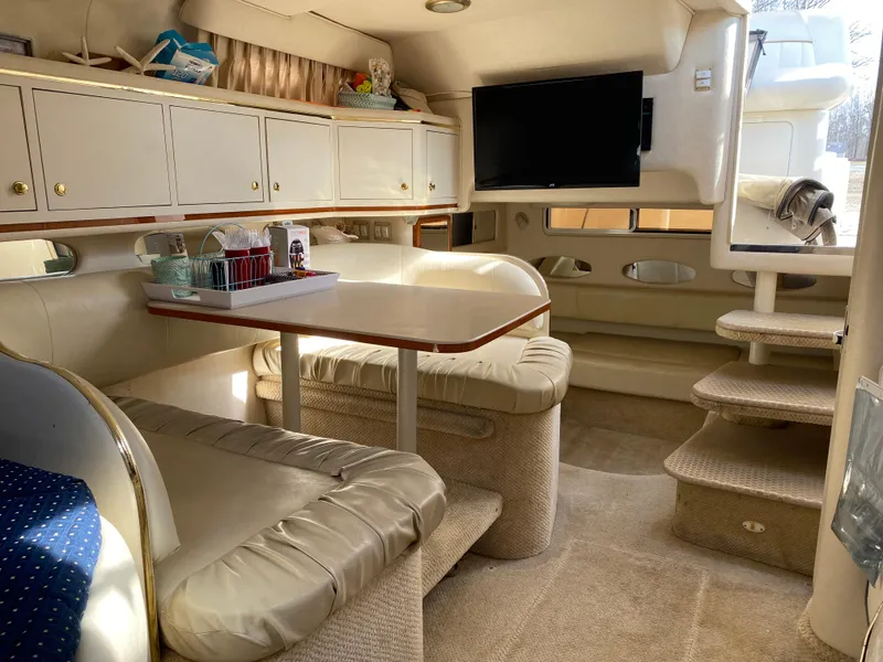 Slide: The Image of 2001 Sea Ray 310 Sundancer interior with seating, table, and TV. Luxurious cabin space. - 47