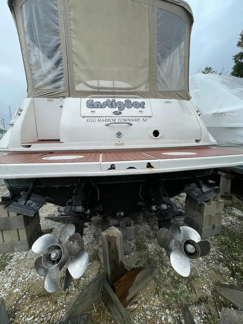 Slide: The Image of 2001 Sea Ray 310 Sundancer boat with dual propellers, docked on blocks. - 6