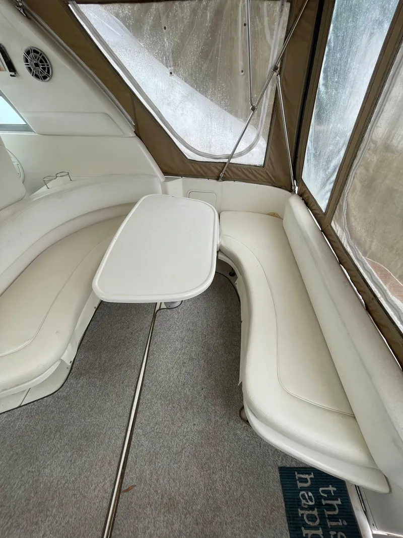 Slide: The Image of Interior of 2001 Sea Ray 310 Sundancer with white seating and table. - 7