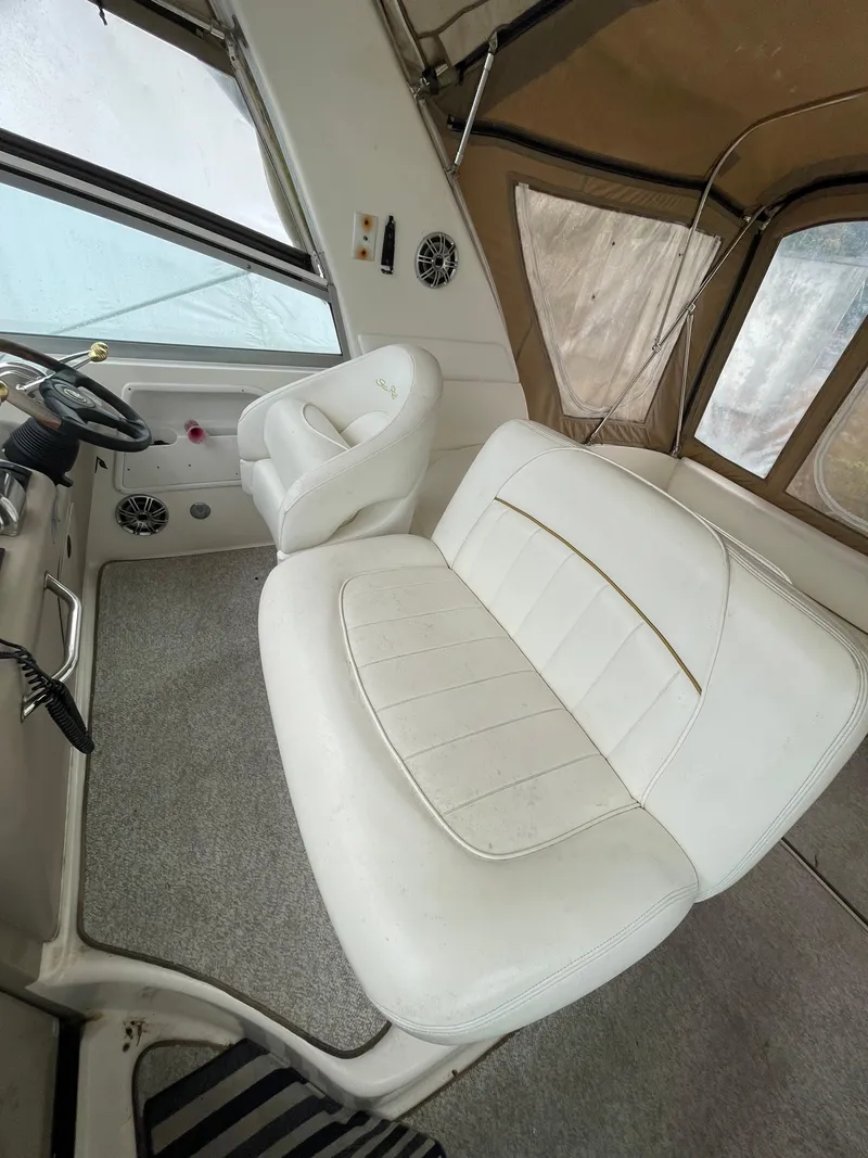 Slide: The Image of 2001 Sea Ray 310 Sundancer interior with white seating and helm, showcasing luxury design. - 9