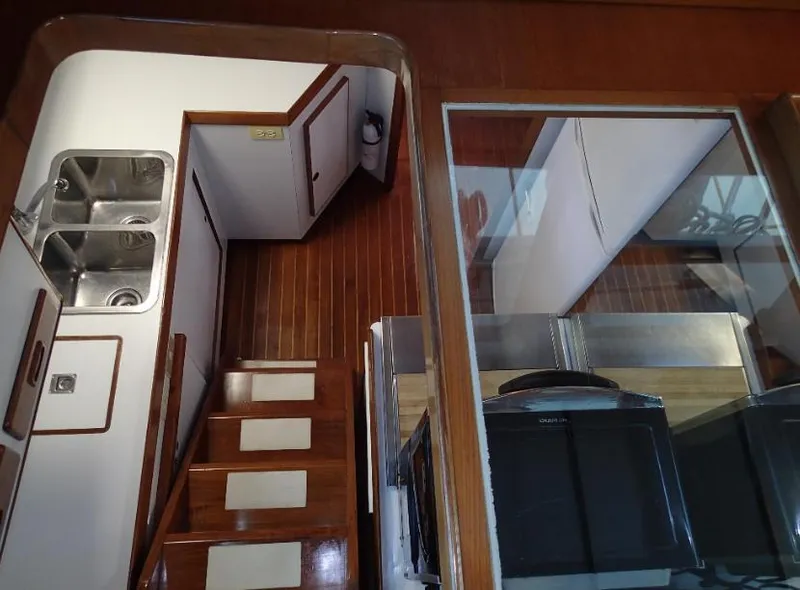 Slide: The Image of Interior of 1987 Tayana 45 Expedition Trawler with wooden stairs and dual sinks. - 16