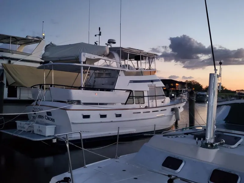 Slide: The Image of 1987 Tayana 45 Expedition Trawler docked at sunset, featuring a spacious deck and classic design. - 2