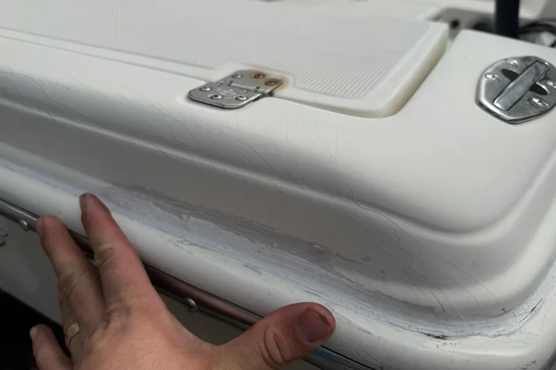 Slide: The Image of Close-up of 2003 Scout 240 Bay Scout boat showing surface wear and hand inspection. - 17