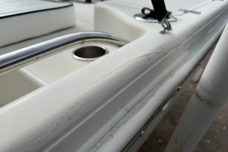 Slide: The Image of Close-up of 2003 Scout 240 Bay Scout boat railing with visible wear and cup holder. - 19