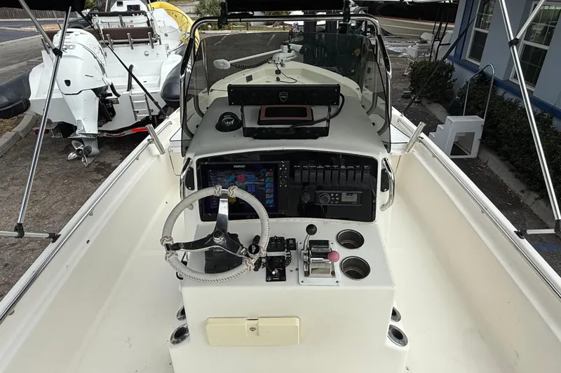 Slide: The Image of 2003 Scout 240 Bay Scout boat cockpit with steering wheel and control panel. - 31