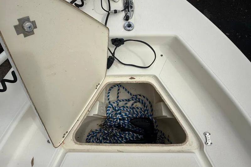 Slide: The Image of Open storage compartment on a 2003 Scout 240 Bay Scout boat with rope inside. - 44