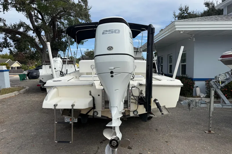 Slide: The Image of 2003 Scout 240 Bay Scout boat with powerful outboard motor, parked outdoors. - 5