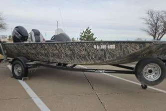 Slide: The Image of 2016 Lowe Stinger 175 boat on trailer, camo design, parked outdoors. - 1