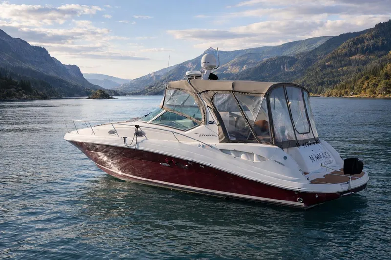 The Image of 2006 Sea Ray 340 Sundancer boat on scenic lake with mountainous backdrop. - 0