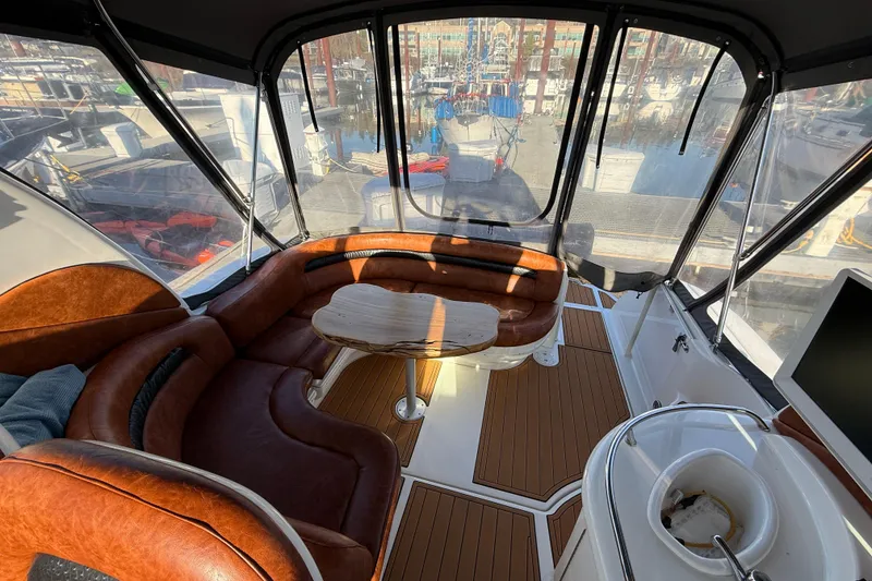 Slide: The Image of Interior of 2006 Sea Ray 340 Sundancer with leather seating and wooden table. - 10