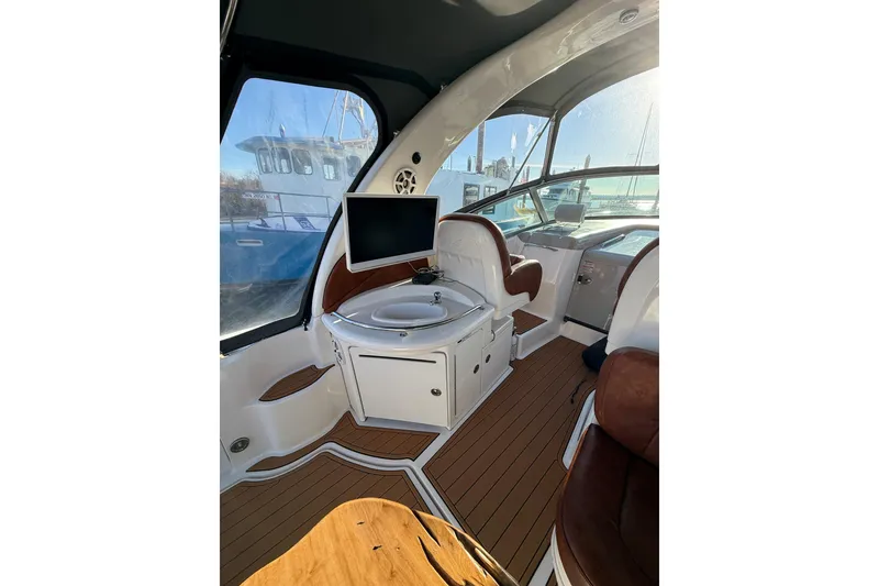 Slide: The Image of Interior of 2006 Sea Ray 340 Sundancer yacht with seating and a mounted TV. - 13