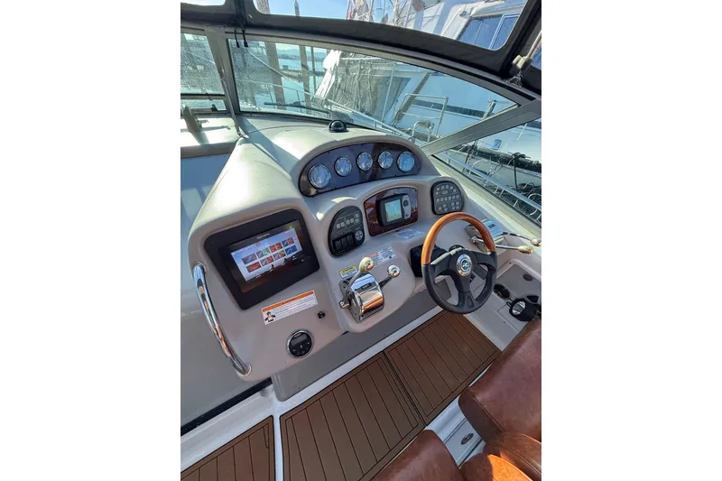 Slide: The Image of 2006 Sea Ray 340 Sundancer helm with modern controls and wood-accented steering wheel. - 15