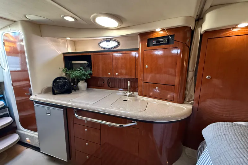 Slide: The Image of 2006 Sea Ray 340 Sundancer interior with elegant wood cabinetry and compact kitchenette. - 23