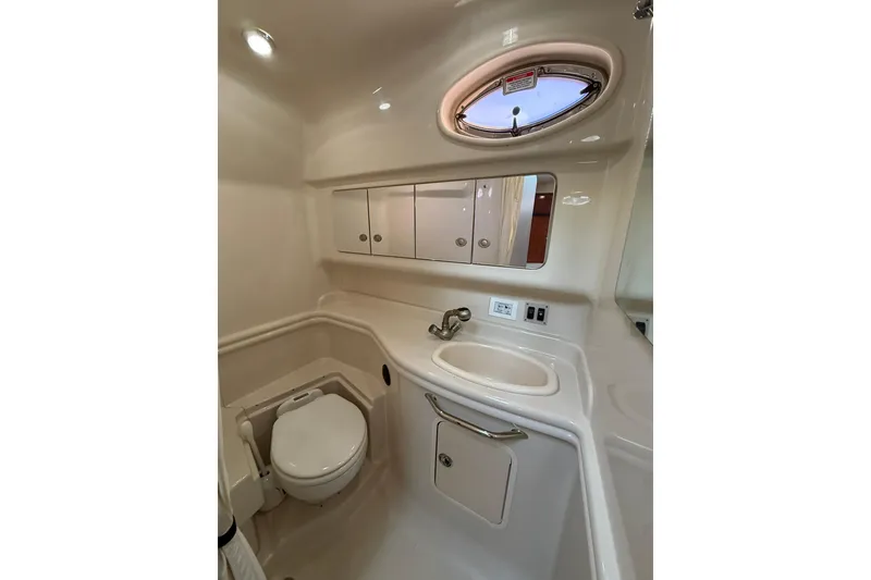Slide: The Image of 2006 Sea Ray 340 Sundancer bathroom with sink, toilet, and mirror cabinet. - 25