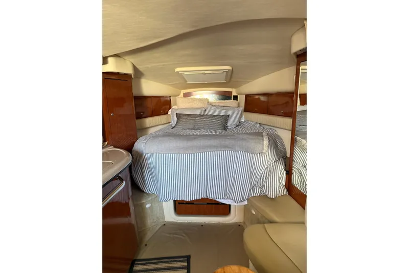 Slide: The Image of Interior cabin of 2006 Sea Ray 340 Sundancer with cozy bed and striped bedding. - 31