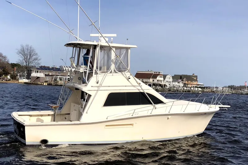 The Image of 1991 Pacemaker 37 Sportfisherman boat on water near residential shoreline. - 0