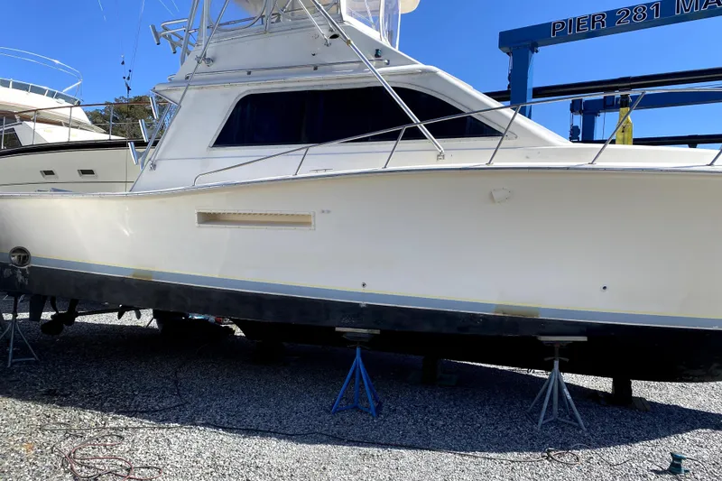 Slide: The Image of 1991 Pacemaker 37 Sportfisherman boat on stands at marina, clear blue sky. - 22