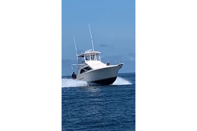 Slide: The Image of 1991 Pacemaker 37 Sportfisherman cruising on open water under clear skies. - 25