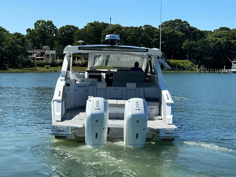 Slide: The Image of 2026 Cruisers Yachts 42 GLS OB on serene water with triple outboard engines. - 7