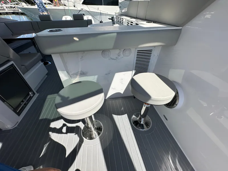 Slide: The Image of Luxurious interior of 2026 Cruisers Yachts 42 GLS OB with plush seating and decorative pillows. - 17