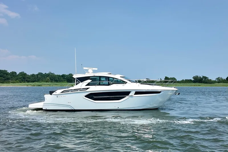 Slide: The Image of 2024 Cruisers Yachts 42 Cantius on water, side view, clear sky background. - 2