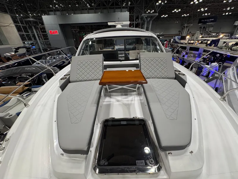 Slide: The Image of 2024 Cruisers Yachts 42 Cantius with luxurious deck seating and table at a boat show. - 21