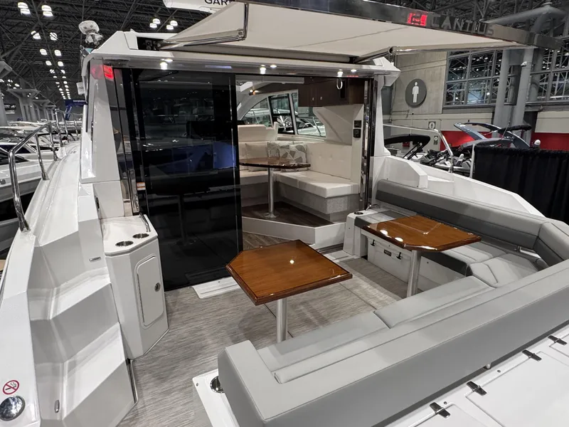 Slide: The Image of 2024 Cruisers Yachts 42 Cantius interior with seating and tables at a boat show. - 4