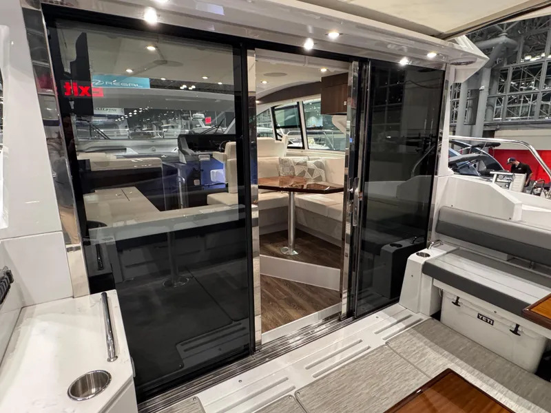 Slide: The Image of 2024 Cruisers Yachts 42 Cantius interior with sliding glass doors and modern seating area. - 10