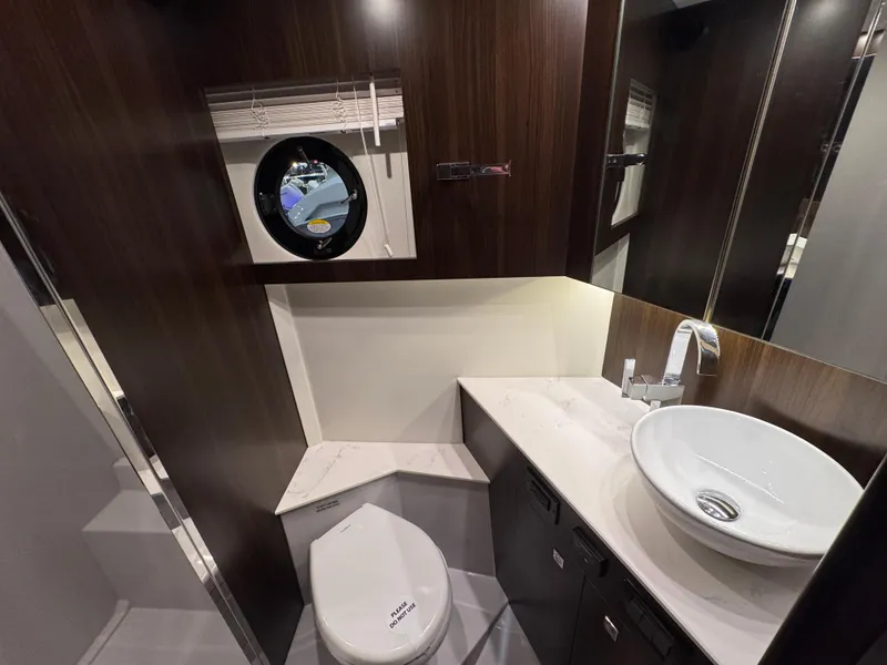 Slide: The Image of Luxurious bathroom in 2024 Cruisers Yachts 42 Cantius with modern fixtures and porthole window. - 20
