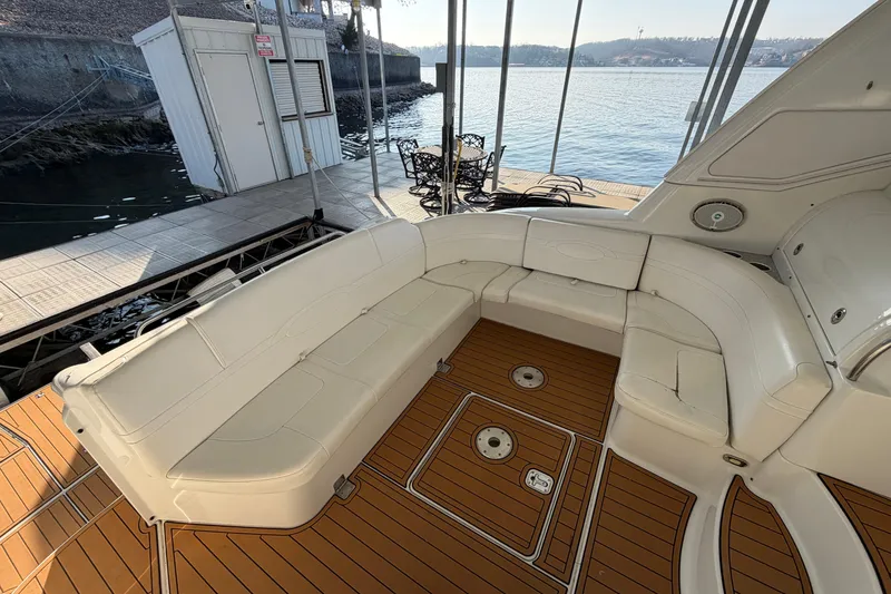 Slide: The Image of Luxurious 2005 Formula 48 Yacht interior with white seating and wooden flooring at a marina. - 11