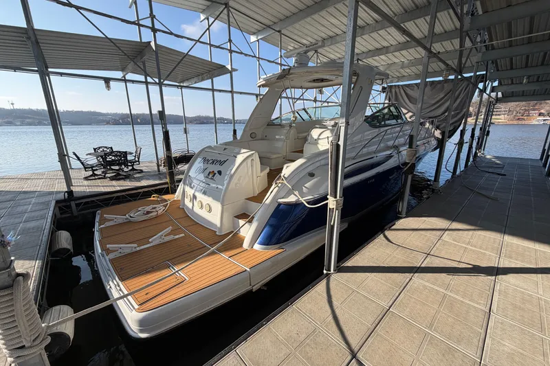 Slide: The Image of 2005 Formula 48 Yacht cruising on a serene lake near a marina. - 2