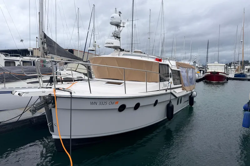 Slide: The Image of 2025 Ranger Tugs R-29 S boat docked in a marina under cloudy skies. - 3