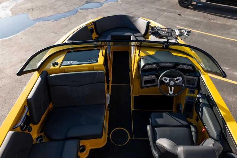 Slide: The Image of 2026 MasterCraft NXT23 boat interior with sleek design, yellow accents, and modern dashboard. - 22