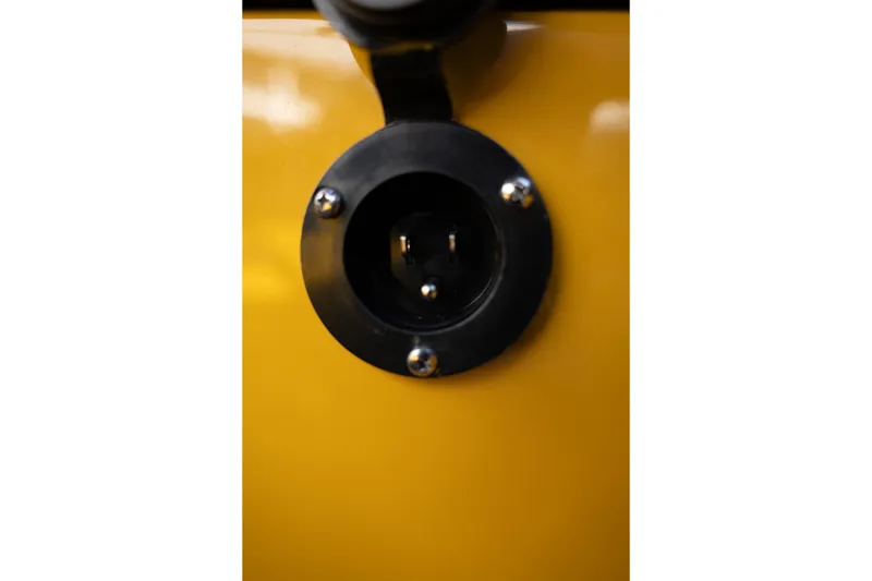 Slide: The Image of Close-up of a 2026 MasterCraft NXT23 boat's yellow exterior with a black circular fixture. - 29