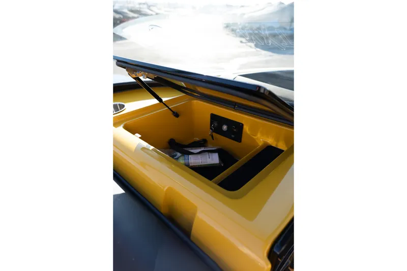 Slide: The Image of Open storage compartment in 2026 MasterCraft NXT23 boat, featuring yellow interior. - 32